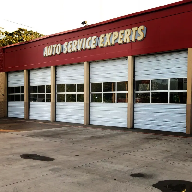Row of commercial garage doors with windows at an auto service shop