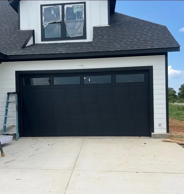 Black modern garage door on a white modern farmhouse