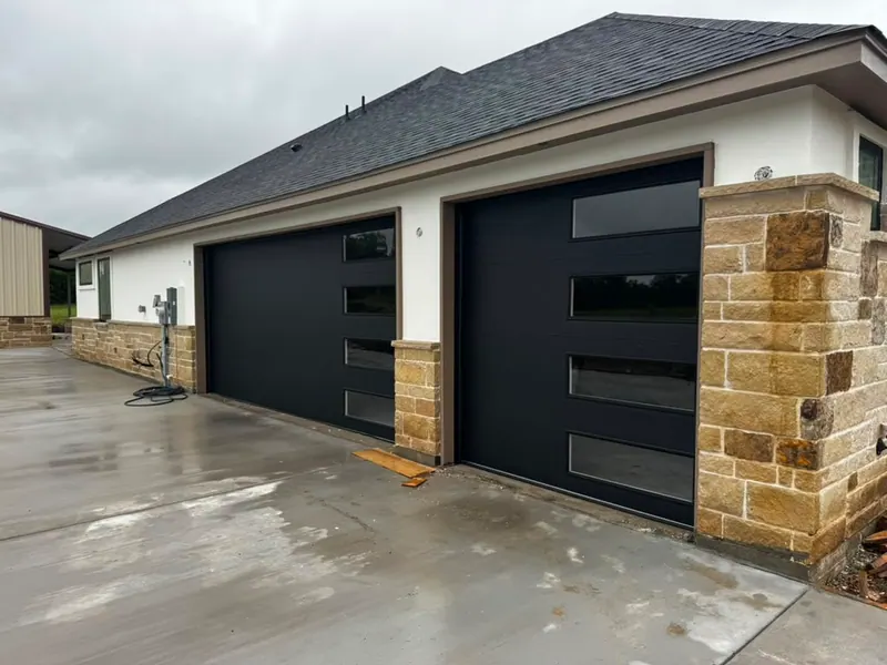 Modern black aluminum and frosted glass garage door on a contemporary Dallas home