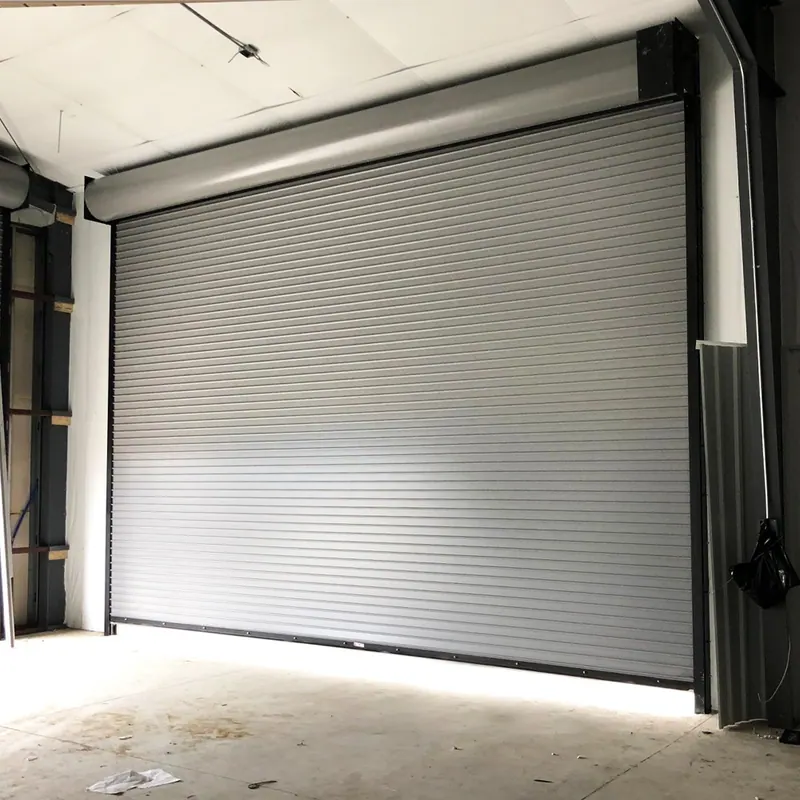 Silver roll up commercial door installed inside a metal building