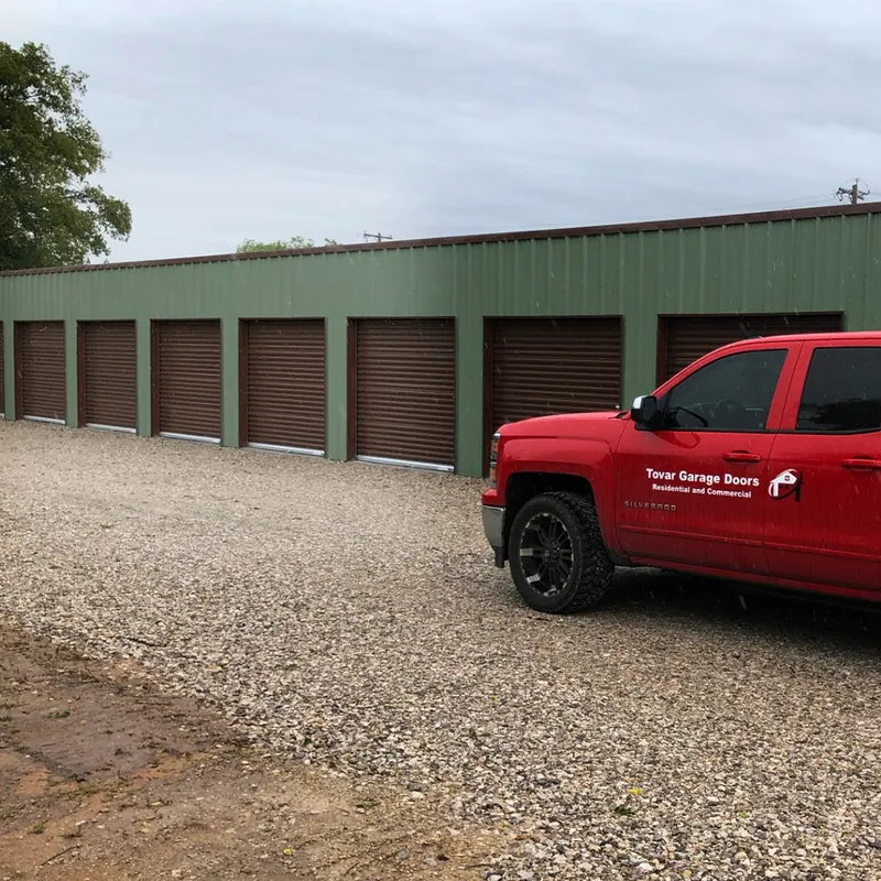 Tovar Garage Doors truck parked in front of a row of storage unit doors