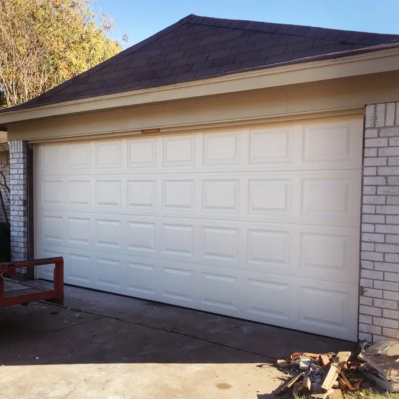 White raised panel garage door on a brick home