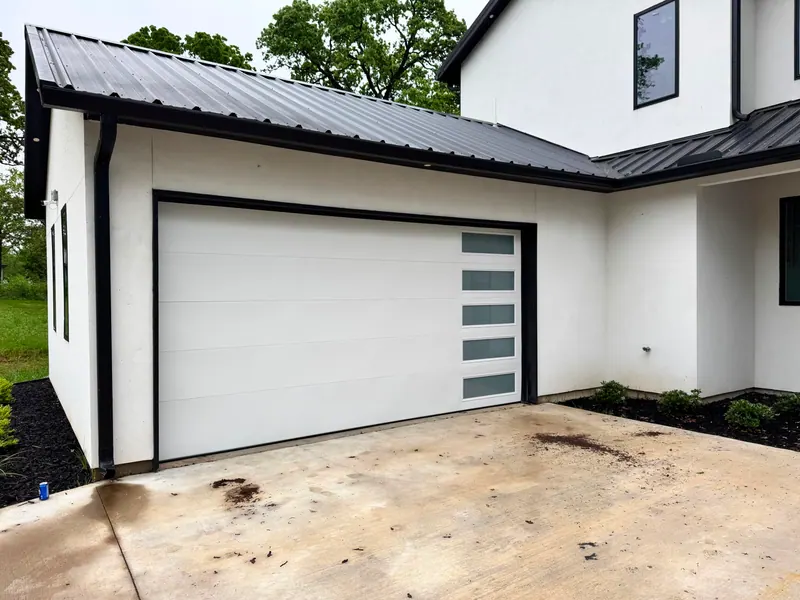 White modern garage door with frosted glass on a luxury modern home