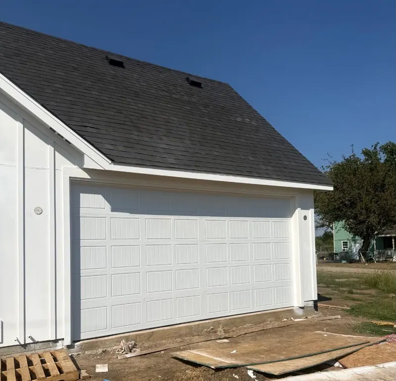 White short panel garage door on a detached garage building
